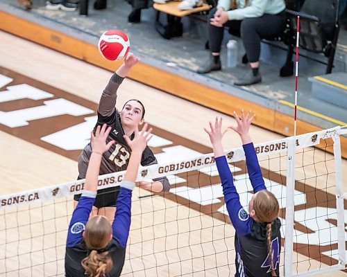 BROOK JONES/FREE PRESS
he Vincent Massey (Brandon) Vikings earned a victory over the Steinbach Sabres in the semi-finals (final four) of the Boston Pizza AAAA Varisty Girls Volleyball Championships hosted by the Maintoba High Schools Athletic Association inside Investors Group Athletic Centre at the University of Manitoba Fort Garry campus in Winnipeg, Man., Wednesday, Nov. 27, 2024. With the win, the Vikings will compete in the MHSAAA provincial volleyball championships at IGAC Monday, Dec. 2, 2024. Pictured: Steinbach Sabres outside hitter Jubilee Steppan (No. 13 ) spikes the volleyball as Vincent Massey Vikings middle Kypling Black (No. 5) and right side/left side Zoe Price (No. 4) go up for the block during second set action.