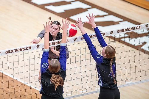 BROOK JONES/FREE PRESS
he Vincent Massey (Brandon) Vikings earned a victory over the Steinbach Sabres in the semi-finals (final four) of the Boston Pizza AAAA Varisty Girls Volleyball Championships hosted by the Maintoba High Schools Athletic Association inside Investors Group Athletic Centre at the University of Manitoba Fort Garry campus in Winnipeg, Man., Wednesday, Nov. 27, 2024. With the win, the Vikings will compete in the MHSAAA provincial volleyball championships at IGAC Monday, Dec. 2, 2024. Pictured: Steinbach Sabres outside hitter Jubilee Steppan (No. 13 ) spikes the volleyball as Vincent Massey Vikings middle Kypling Black (No. 5) and Vikings teammate right side/left side Zoe Price (No. 4) go up for the block during second set action.