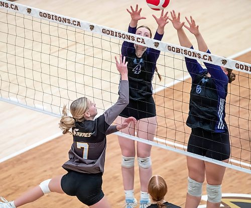 BROOK JONES/FREE PRESS
he Vincent Massey (Brandon) Vikings earned a victory over the Steinbach Sabres in the semi-finals (final four) of the Boston Pizza AAAA Varisty Girls Volleyball Championships hosted by the Maintoba High Schools Athletic Association inside Investors Group Athletic Centre at the University of Manitoba Fort Garry campus in Winnipeg, Man., Wednesday, Nov. 27, 2024. With the win, the Vikings will compete in the MHSAAA provincial volleyball championships at IGAC Monday, Dec. 2, 2024. Pictured: Steinbach Sabres outside hitter Kiersten Reimer (No. 7) taps the volleyball over the net as Vincent Massey Vikings right side/left side Zoe Price (No. 4) and Vikings teammate middle Kypling Black (No. 5) go up for the block during third set action.