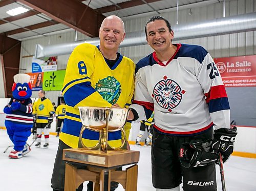 BROOK JONES/FREE PRESS
The City of Winnipeg and the Province of Manitoba rekindled a half-century old hockey rivalry at Gateway Recreation Centre in Winnipeg, Man., Saturday, Nov. 30, 2024. The friendly hockey game between politicans, Winnipeg's public service and provincial staff was held in celebration of Winnipeg's 150th anniversary. The City earned a 6-0 victory over the Province. Pictured: Winnipeg Mayor Scott Gillingham (left) shakes hands with Manitoba Premier Wab Kinew after the hockey game as they gather around the championship trophy which was first presented 50 years ago to the winning team when the city led by then mayor Stephen Juba took on the province led by then premier Edward Schreyer.