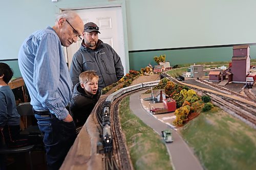 James Smith, 7, (middle) shows excitment as trains move on the HO-scale model railway layout built by the club in five years at the Commonwealth Air Training Plan Museum, located in Building D at the Brandon Airport Saturday afternoon while Brandon Hills Model Railway Club member Bill McGuire (left) and Smith's father, Chris, look on. (Abiola Odutola/The Brandon Sun)