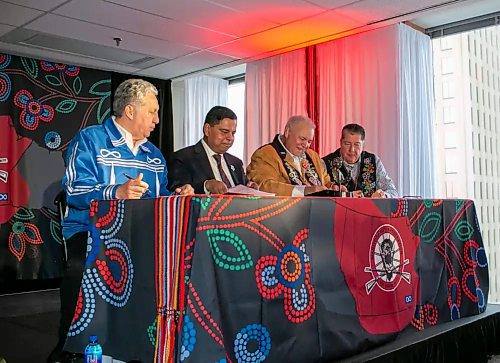 Manitoba Métis Federation President David Chartrand (second from right) signs a copy of the Red River Métis Self Government Treaty at the MMF building in Winnipeg, along with (from left) Minster of Norther Affairs Dan Vandal, Federal Minister of Crown-Indigenous Relations Gary Anandasangaree and lead negotiator for the Red River Métis Allan Benoit. (Brook Jones/Winnipeg Free Press)