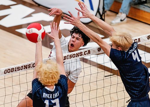 JOHN WOODS / WINNIPEG FREE PRESS
St Paul&#x2019;s Crusaders&#x2019; Keon Elkie (3) hits against River East Kodiaks&#x2019; Nikolas Horton (13) and Matthew Brown (4) in the Manitoba High School 2022 AAAA Varsity Volleyball Provincial Championship at the University of Manitoba Monday, December 2, 2024.