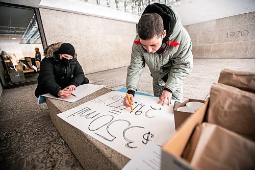 MIKAELA MACKENZIE / FREE PRESS
	
Owen Toews (left) and Michelle Dallmann make signs outside of End Homelessness Winnipeg&#x573; conference at the Winnipeg Art Gallery on Tuesday, Dec. 3, 2024. 

For Nicole Buffie story.
Winnipeg Free Press 2024