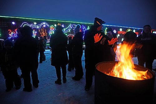 05122024
Carberry and area residents stay warm around a fire and check out the Christmas lights on the CPKC Holiday Train during the trains stop in Carberry on Thursday evening. The annual holiday train has been running since 1999 and raises money for food banks in North America. According to CPKC more than $24.3 million and more than 5.3 million pounds of food has been donated. During the performance a check for $2500 was presented to the Carberry Food Cupboard. Non-perishable items were also collected for the local food cupboard. The Holiday train made an earlier stop in Portage la Prairie before finishing the night with a stop and performance in Brandon. It continues west today its first stop in Virden. 
(Tim Smith/The Brandon Sun)
