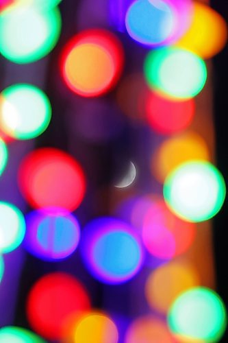 The crescent moon is seen through Christmas lights at Princess Park while rising over Brandon on a mild Friday evening. The next full moon will occur on December 15. (Tim Smith/The Brandon Sun)
