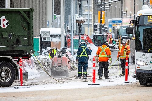 MIKAELA MACKENZIE / FREE PRESS
	
Construction workers at the south west corner of Portage and Main as the concrete barrier starts to get taken down on Tuesday, Dec. 10, 2024.


Winnipeg Free Press 2024