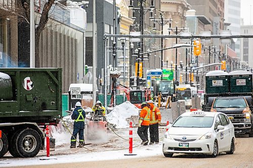 MIKAELA MACKENZIE / FREE PRESS
	
Construction workers at the south west corner of Portage and Main as the concrete barrier starts to get taken down on Tuesday, Dec. 10, 2024.


Winnipeg Free Press 2024