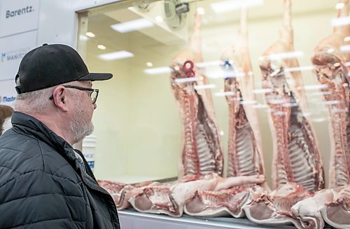 BROOK JONES/FREE PRESS
Johnny Gross from Westroc Hutterite Colony looks at hog carcasses displayed at the Pork Quality Competition during the Prairie Livestock Expo at the Victoria Inn in Winnipeg, Man., Wednesday, Dec. 11, 2024.