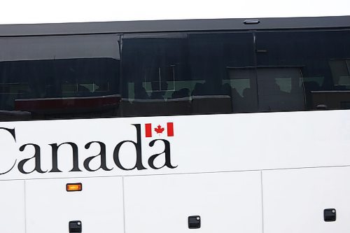 The silhouette of soldiers is cast through the window of a bus leaving CFB Shilo on Friday, Dec. 13. Multiple busses carrying roughly 175 soldiers left on Dec. 13, completing the deployment of about 500 soldiers from Shilo take took place over several weeks beginning in November. (Connor McDowell/Brandon Sun)