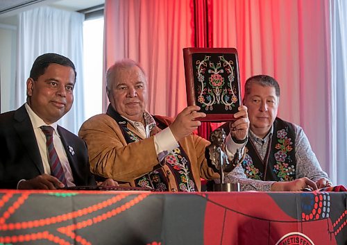 BROOK JONES/FREE PRESS
Manitoba M&#xe9;tis Federation President David Chartrand (middle) holds up a copy of the Red River M&#xe9;tis Self Government Treaty beween the Manitoba M&#xe9;tis Federation, National Government of the Red River M&#xe9;tis and his His Majesty King Charles III on bahalf of the Crown and the Government of Canada. The treaty signing ceremony took place at the MMF building at 333 Main St., in Winnipeg, Man., Saturday, Nov. 30, 2024. Pictured: Manitoba M&#xe9;tis Federation President David Chartrand (left) and lead negotiator for the Red River M&#xe9;tis Allan Benoit. The bead work on the treaty cover was done by Jennine Krauchi Pictured: L-R: Federal Minister of Crown-Indigenous Relations Gary Anandasangaree, Chartrand and lead negotiator for the Red River M&#xe9;tis Allan Benoit.