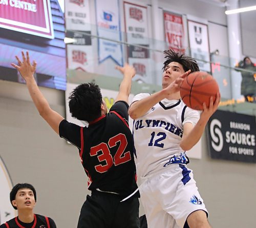 College Jeanne-Sauve's Eric Schlag (12) attempts a layup while Sisler's Emile Vandal (32) does his best to defend. (Matt Packwood/The Brandon Sun)