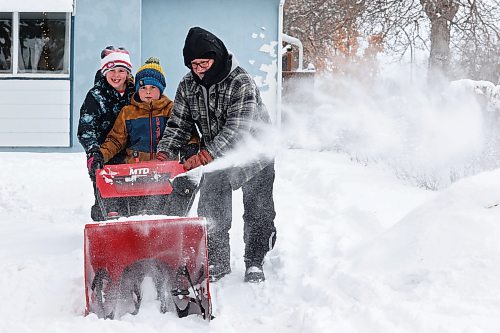 16122024
Siblings Paisley and Zander Livingstone use a snowblower with help from their neighbour Roger McCannel to clear fresh snow from the Livingstone family&#x2019;s walkway on Monday. 
(Tim Smith/The Brandon Sun)