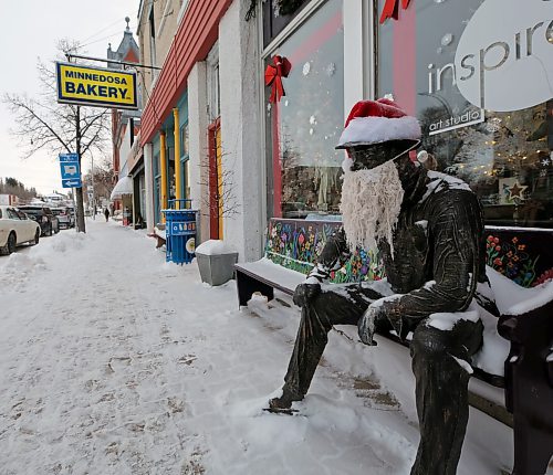 Art Van Winkel — the stationary fixture outside a Minnedosa art store — got his head back in the right place this Christmas season. Art lost his head (literally!) to thieves several times this year. As part of the latest attempt to capitate him, Art now has a camera pointed at his head for surveilling any mischief makers, as well as an air tag installed within. He is seen here on Tuesday afternoon, at his usual perch in front of the Inspire Art Studio — all decked up for the holidays — wearing a Santa hat and a beard. (Connor McDowell/The Brandon Sun) 