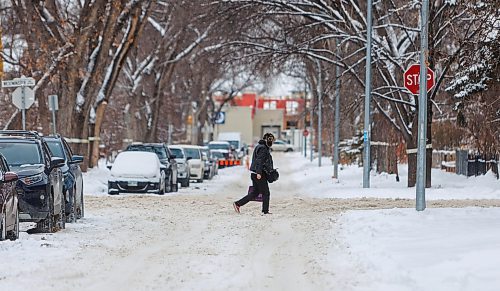 MIKE DEAL / FREE PRESS
Pedestrians navigate the snow covered street along Westminster Avenue Tuesday afternoon. The city will conduct a full residential street plow starting Wednesday evening.
Reporter: Malak Abas
241217 - Tuesday, December 17, 2024.