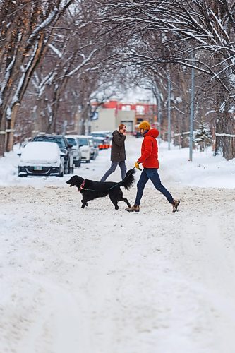 MIKE DEAL / FREE PRESS
Pedestrians navigate the snow covered street along Westminster Avenue Tuesday afternoon. The city will conduct a full residential street plow starting Wednesday evening.
Reporter: Malak Abas
241217 - Tuesday, December 17, 2024.