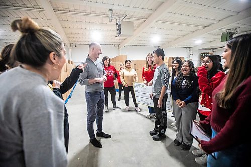 MIKAELA MACKENZIE / FREE PRESS
	
Dakota Collegiate grade 10-12 students laugh after presenting a cheque to Cheer Board executive director Shawna Bell and Paul Samyn as part of Miracle on Mountain on Tuesday, Dec. 17, 2024.


Winnipeg Free Press 2024