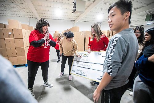 MIKAELA MACKENZIE / FREE PRESS
	
Cheer Board executive director Shawna Bell (left) and Dakota Collegiate grade 12 students Waner Sai, Taylor Pritchard, and Derek Tieu laugh after present a cheque as part of Miracle on Mountain on Tuesday, Dec. 17, 2024.


Winnipeg Free Press 2024