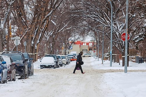 MIKE DEAL / FREE PRESS
Pedestrians navigate the snow covered street along Westminster Avenue Tuesday afternoon. The city will conduct a full residential street plow starting Wednesday evening.
Reporter: Malak Abas
241217 - Tuesday, December 17, 2024.