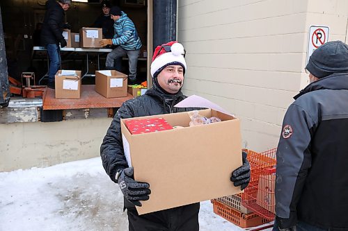 17122024
Gage Wood with Brandon Fire &amp; Emergency Services helps load Christmas hampers into waiting vehicles outside Brandon-Westman Christmas Cheer on 7th Street in Brandon on Wednesday. Volunteers worked all day and evening Wednesday to prep and send out Christmas hampers to families in need for the holidays. Volunteers will be back at it today to deliver the remainder of the hampers.
(Tim Smith/The Brandon Sun)