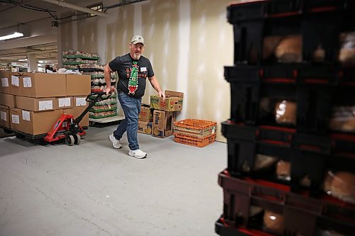 17122024
Jim Saltesz moves a pallet loaded with Christmas hampers through the warehouse at Brandon-Westman Christmas Cheer on 7th Street in Brandon on Wednesday. Volunteers worked all day and evening Wednesday to prep and send out Christmas hampers to families in need for the holidays. Volunteers will be back at it today to deliver the remainder of the hampers.
(Tim Smith/The Brandon Sun)