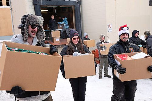 17122024
Scott Ryan, Kaitlyn May and Gage Wood with Brandon Fire &amp; Emergency Services help load Christmas hampers into waiting vehicles outside Brandon-Westman Christmas Cheer on 7th Street in Brandon on Wednesday. Volunteers worked all day and evening Wednesday to prep and send out Christmas hampers to families in need for the holidays. Volunteers will be back at it today to deliver the remainder of the hampers.
(Tim Smith/The Brandon Sun)