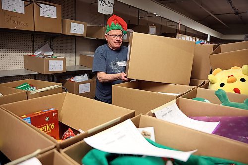 17122024
Duncan Waddell wears a festive elf hat while organizing and moving Christmas hampers at Brandon-Westman Christmas Cheer on 7th Street in Brandon on Wednesday. Volunteers worked all day and evening Wednesday to prep and send out Christmas hampers to families in need for the holidays. Volunteers will be back at it today to deliver the remainder of the hampers.
(Tim Smith/The Brandon Sun)