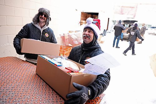 17122024
Scott Ryan and Gage Wood with Brandon Fire &amp; Emergency Services help load Christmas hampers into waiting vehicles outside Brandon-Westman Christmas Cheer on 7th Street in Brandon on Wednesday. Volunteers worked all day and evening Wednesday to prep and send out Christmas hampers to families in need for the holidays. Volunteers will be back at it today to deliver the remainder of the hampers.
(Tim Smith/The Brandon Sun)