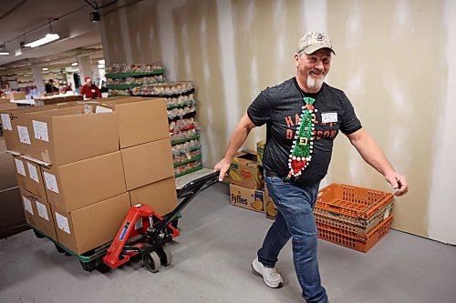 17122024
Jim Saltesz moves a pallet loaded with Christmas hampers through the warehouse at Brandon-Westman Christmas Cheer on 7th Street in Brandon on Wednesday. Volunteers worked all day and evening Wednesday to prep and send out Christmas hampers to families in need for the holidays. Volunteers will be back at it today to deliver the remainder of the hampers.
(Tim Smith/The Brandon Sun)