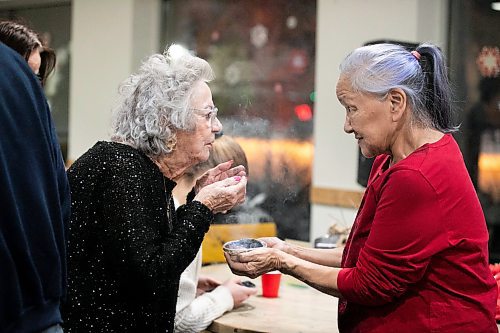 MIKAELA MACKENZIE / FREE PRESS
	
Elder Martha Peet (right) and Cheryl Krevesky smudge before the Winter Solstice Feast at NorWest Co-op on Thursday, Dec. 19, 2024.

Standup.
Winnipeg Free Press 2024