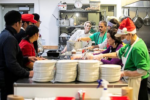 MIKAELA MACKENZIE / FREE PRESS
	
Chef Melanie Ryan (centre) directs volunteers serving up plates at the Winter Solstice Feast at NorWest Co-op on Thursday, Dec. 19, 2024.

Standup.
Winnipeg Free Press 2024