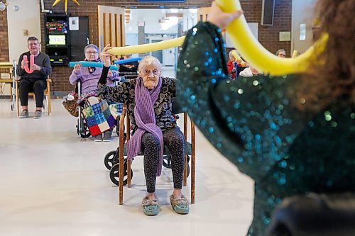 MIKE DEAL / FREE PRESS
Ellen wearing a long purple scarf raises her noodle above her head while participating in &#x201c;noodle hockey&#x201d; a popular recreation activity at Fred Douglas Lodge (1275 Burrows Ave). 

Reporter: Maggie Macintosh
241219 - Thursday, December 19, 2024.