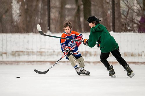 BROOK JONES/FREE PRESS
Nine-year-old Charlie Dube, who is pictured wearing a Connor McDavid Edmonton Oilers hockey jersey, and his older brother Benz Dube, 11, play a friendly game of keep away on an outdoor rink at the Wildwood Park Community Centre on a mild Boxing Day in Winnipeg, Man. The capital region was experiencing warm winter weather for the Christmas holidays as the daytime temperature was hovering around 0 C on Thursday, Dec. 26, 2024.