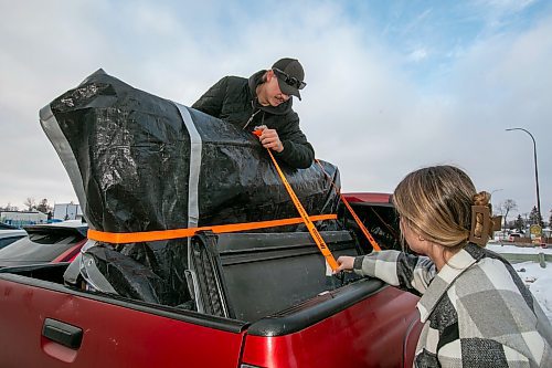 BROOK JONES/FREE PRESS
Dylan Hancox, 25, (left) and his fianc&#xe9;e Reanne Poirier, 25, who are from New Bothwell, Man., secure a 75-inch Hisense TV with tie-downs to a pickup truck bed after shopping at Visions Electronics on Pembina Highway on Boxing Day in Winnipeg, Man., Thursday, Dec. 26, 2024.