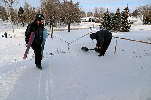 Maurice Rule builds a jump leading into the handrail in Rideau Park. Professional skier Alex Hall walks to the top of the hill before setting off on a run. (Connor McDowell/The Brandon Sun)