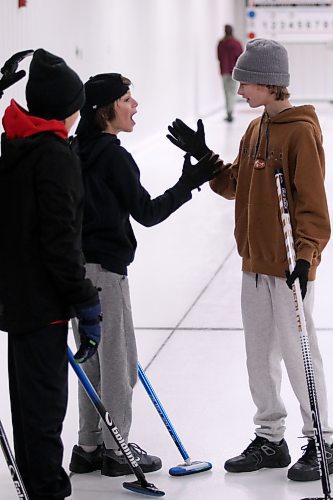 Jaxon Stanley and Cruz Dueck high five each other after picking up a win on Saturday at the Miniota Curling Club. (Matt Packwood/The Brandon Sun)