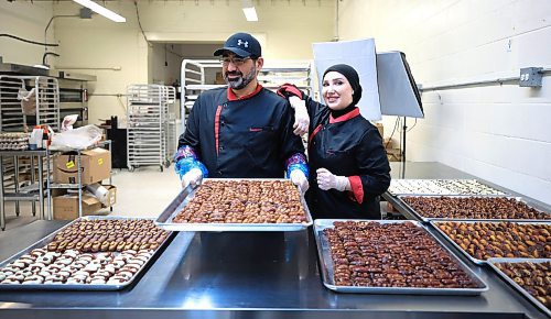 RUTH BONNEVILLE / FREE PRESS
Noura Hamwi and husband Anas Albouchi prepare batches of their nut-filled, chocolate-covered dates at a commercial kitchen in Windsor Park.