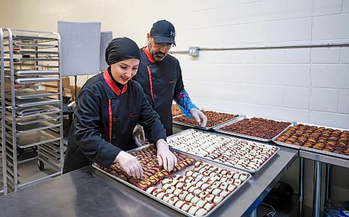 RUTH BONNEVILLE / FREE PRESS
Noura Hamwi and husband Anas Albouchi prepare batches of their nut-filled, chocolate-covered dates at a commercial kitchen in Windsor Park.