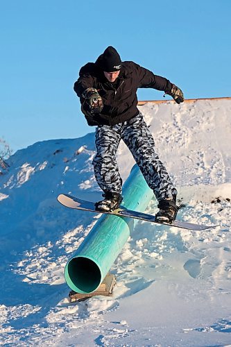 15012025
Chris Campbell boardslides a rail while snowboarding in a backyard park he built with friends at his home along 17th Avenue East in Brandon on a sunny and warm Wednesday afternoon. Campbell built the majority of the park before the snow fell and he and his friends have been riding since the first snowfall. 
(Tim Smith/The Brandon Sun)