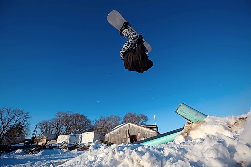 15012025
Chris Campbell backflips off a pole-jam while snowboarding in a backyard park he built with friends at his home along 17th Avenue East in Brandon on a sunny and warm Wednesday afternoon.
(Tim Smith/The Brandon Sun)