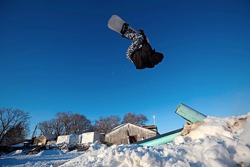 15012025
Chris Campbell backflips off a pole-jam while snowboarding in a backyard park he built with friends at his home along 17th Avenue East in Brandon on a sunny and warm Wednesday afternoon.
(Tim Smith/The Brandon Sun)