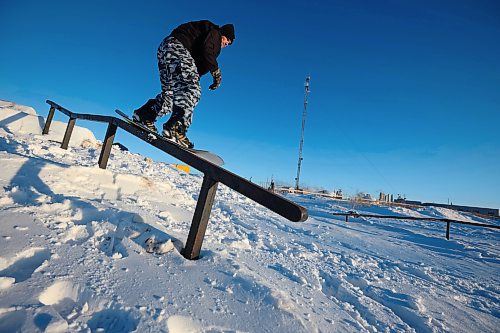 15012025
Chris Campbell grinds a rail while snowboarding in a backyard park he built with friends at his home along 17th Avenue East in Brandon on a sunny and warm Wednesday afternoon. Campbell built the majority of the park before the snow fell and he and his friends have been riding since the first snowfall. 
(Tim Smith/The Brandon Sun)