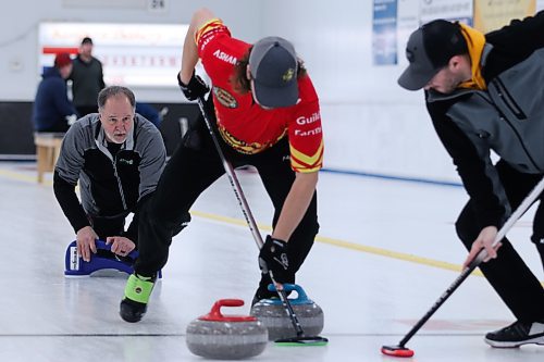 Allan West looks on as his sweepers help a rock into position in the men's A-side final on Sunday. (Matt Packwood/The Brandon Sun)