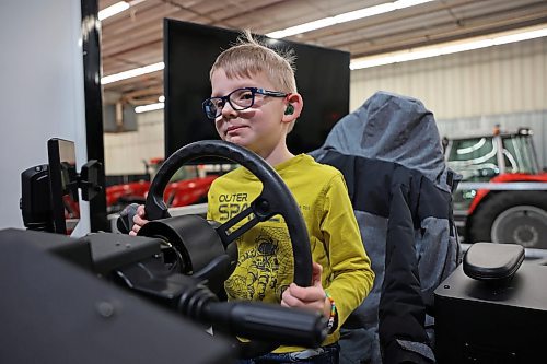 20012025
Six-year-old Fynn Raupers sits at a Fendt simulator set up for tractor and planting simulation while his dad Martin Raupers, Field After-Sales Manager for AGCO, sets up their booth and displays with other employees ahead of Manitoba Ag Days at the Keystone Centre in Brandon on Monday. Ag Days kicks off today and runs until Thursday. 
(Tim Smith/The Brandon Sun)