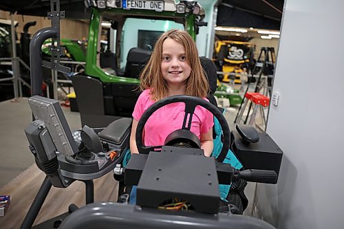 20012025
Eight-year-old Hazel Raupers sits at a Fendt simulator set up for sprayer simulation while her dad Martin Raupers, Field After-Sales Manager for AGCO, sets up their booth and displays with other employees ahead of Manitoba Ag Days at the Keystone Centre in Brandon on Monday. Ag Days kicks off today and runs until Thursday. 
(Tim Smith/The Brandon Sun)