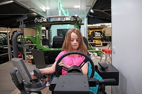 20012025
Eight-year-old Hazel Raupers sits at a Fendt simulator set up for sprayer simulation while her dad Martin Raupers, Field After-Sales Manager for AGCO, sets up their booth and displays with other employees ahead of Manitoba Ag Days at the Keystone Centre in Brandon on Monday. Ag Days kicks off today and runs until Thursday. 
(Tim Smith/The Brandon Sun)