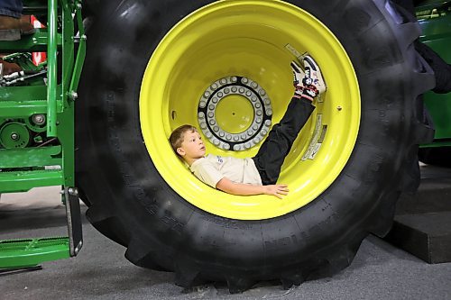 23012025
Atlas Friesen, six, of Altona, rests in the wheel well of a John Deere combine during the final day of Manitoba Ag Days at the Keystone Centre on Thursday.
(Tim Smith/The Brandon Sun)