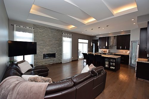 Todd Lewys / Free Press
A gorgeous great room with lit vaulted ceiling with angled drywalled detailing and gas fireplace set in a floor-to-ceiling stone feature wall serves as a perfect counterpoint to the stunning kitchen.
