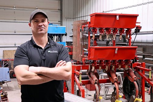 Robertson in front of one of the seed drills he uses as a senior research analyst in his 9-5 job with AgQuest. (Matt Packwood/The Brandon Sun)