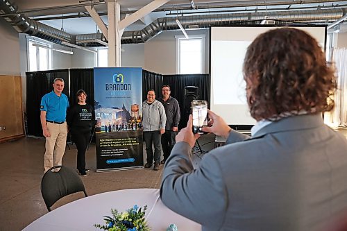 05022025
Brandon Mayor Jeff Fawcett takes photos of City Councillor and Chair of the Keystone Centre Board Bruce Luebke, Brandon First Executive Director Jenn Watson, City Councillor Jason Splett and Brandon First Board Chairperson Chris Heide with the new Brandon First branding after the unveiling at the Dome Building on Thursday. 
(Tim Smith/The Brandon Sun)
